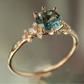 Gold geometric claw setting ring with inlaid zircon stone on a band with a square pattern.
