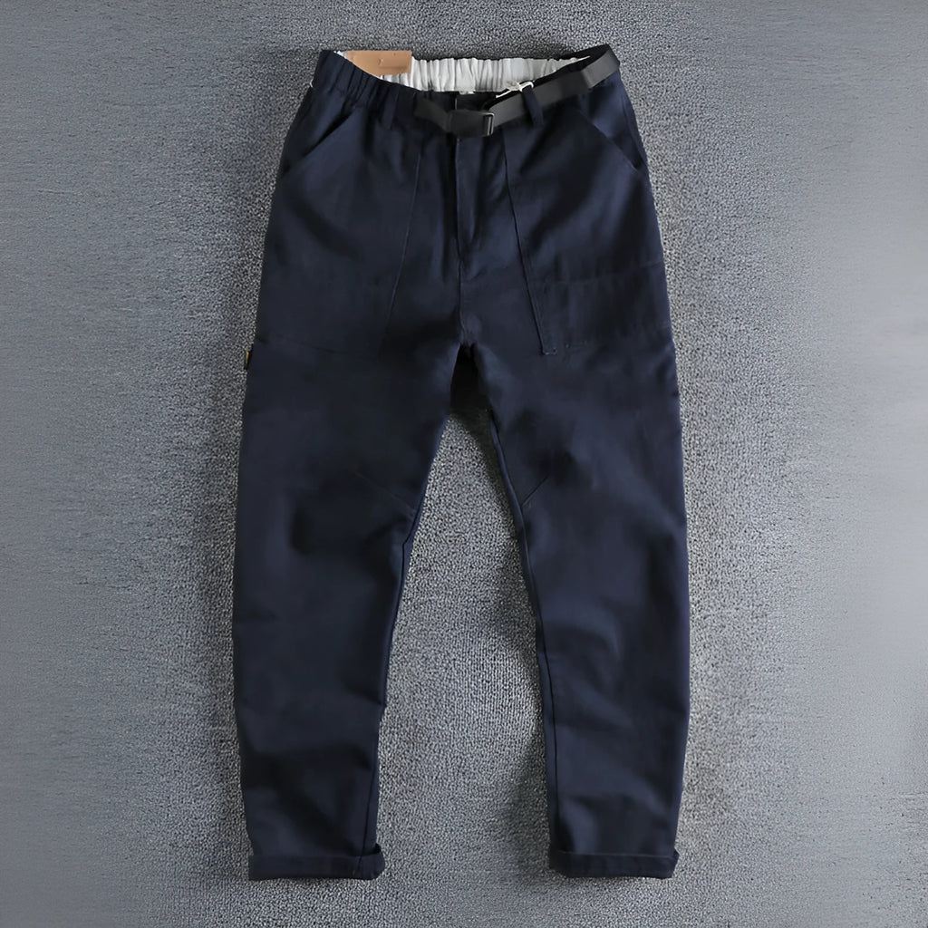 Man's khaki cotton canvas work trousers with 3D cut, showing mid-rise waist and zipper fly.