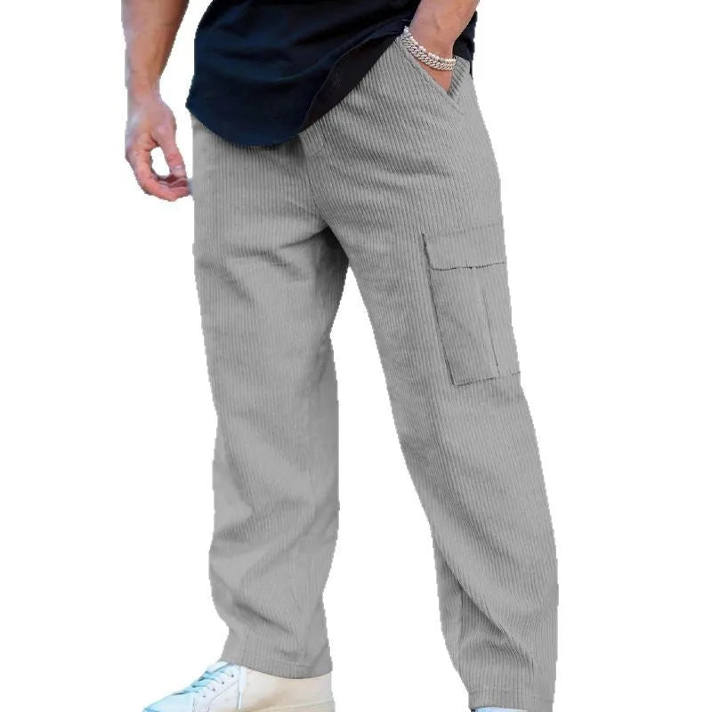 Man wearing loose-fitting navy blue corduroy cargo trousers with a straight leg and drawstring waist.