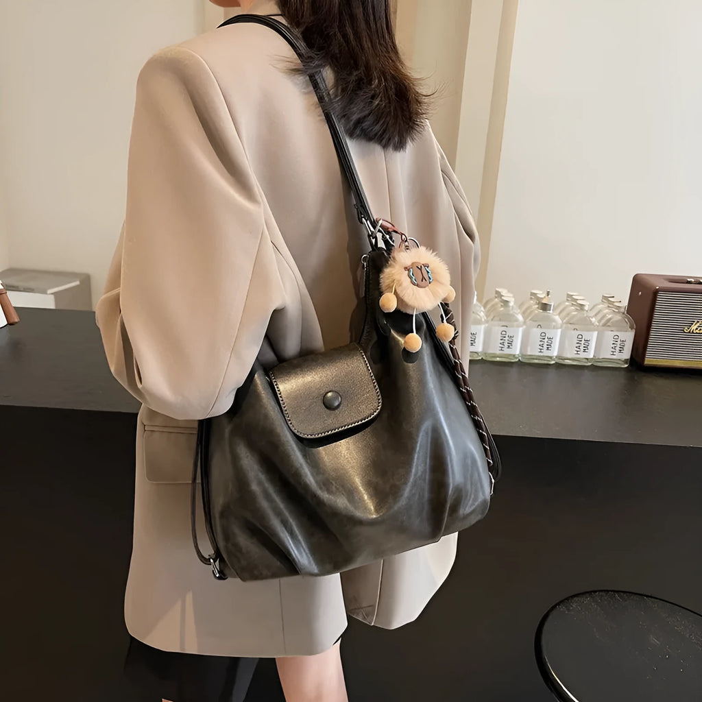 Textured PU leather commuter shoulder backpack in horizontal square shape with single strap and mobile phone compartment