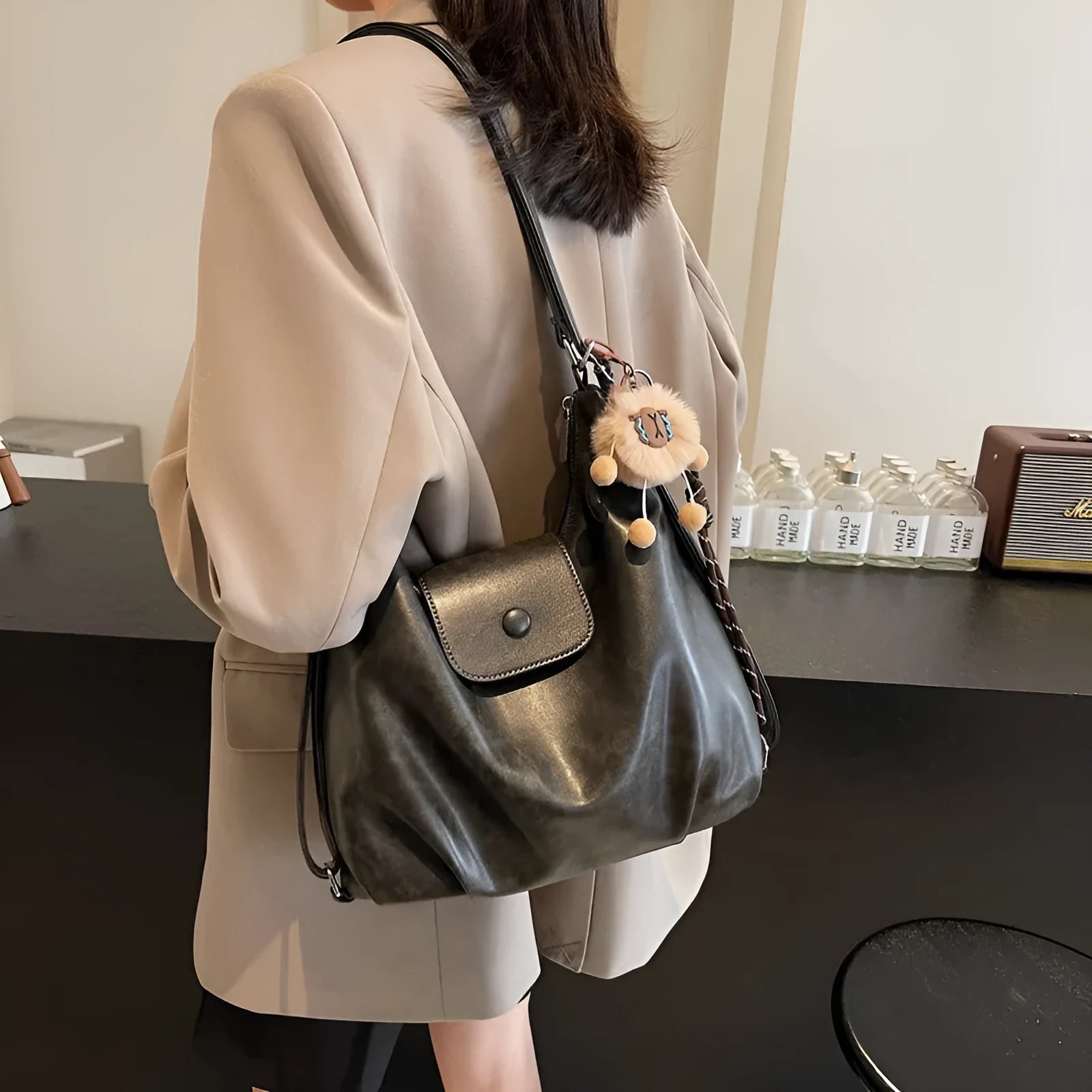 Textured PU leather commuter shoulder backpack in horizontal square shape with single strap and mobile phone compartment