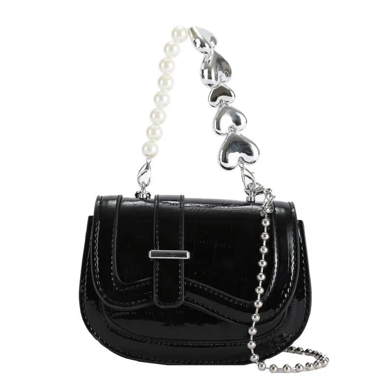 Silver laser pearl tote saddle girl mini crossbody bag with single strap on a mannequin.
