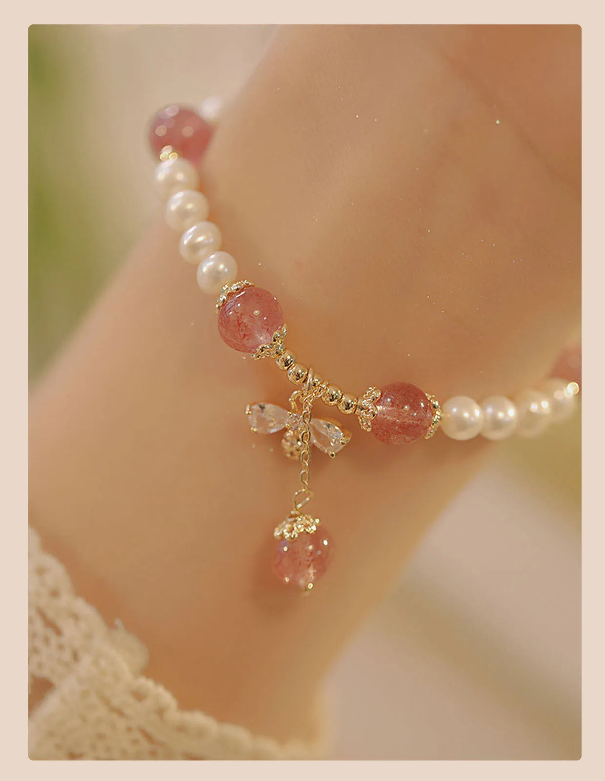 Women's handmade strawberry quartz and crystal bracelet with a decorative bow on a string of beads.