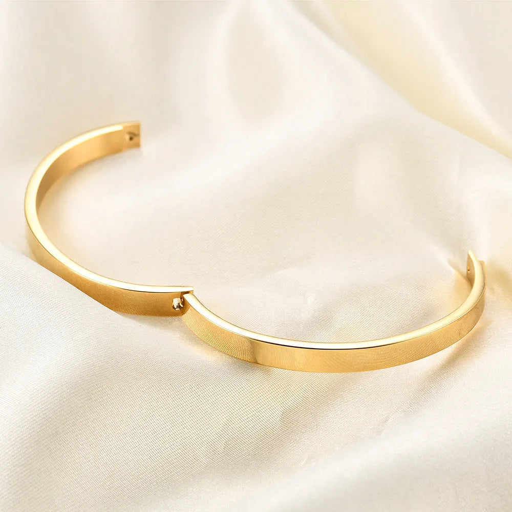 Polished stainless steel snap bracelet with oval links on plain background