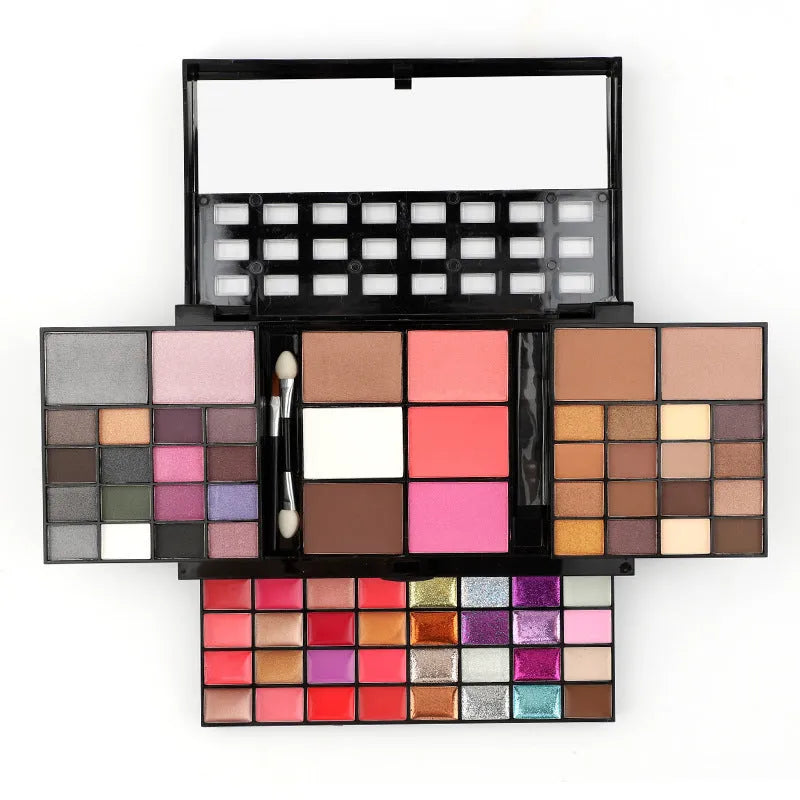 Open 74-colour makeup palette showing four layers of eyeshadow, lip gloss, blush, and contour powders with included brushes.