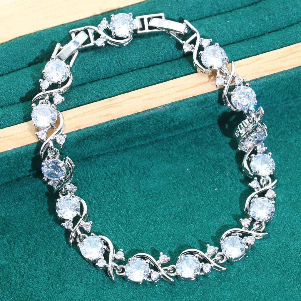 Four-piece bridal jewellery set with water wave chain necklace, bracelet, earrings, and ring in alloy with zircon detailing