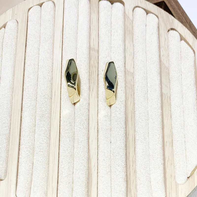 Irregular C-shaped metal stud earrings in Gold finish, minimalist design for everyday wear.