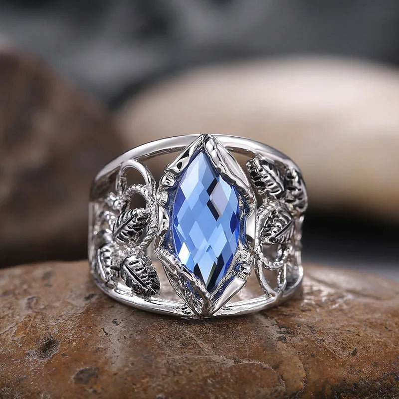 Blue crystal inlaid in a geometric horse eye shape on an alloy women's ring.