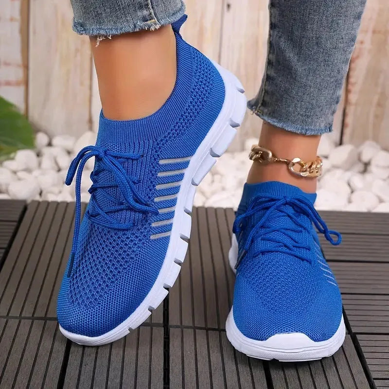 Breathable women's casual flat shoes in flying knit mesh with front lace tie.