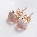 Rose gold drop-shaped stud earrings with crystal inlay detail.