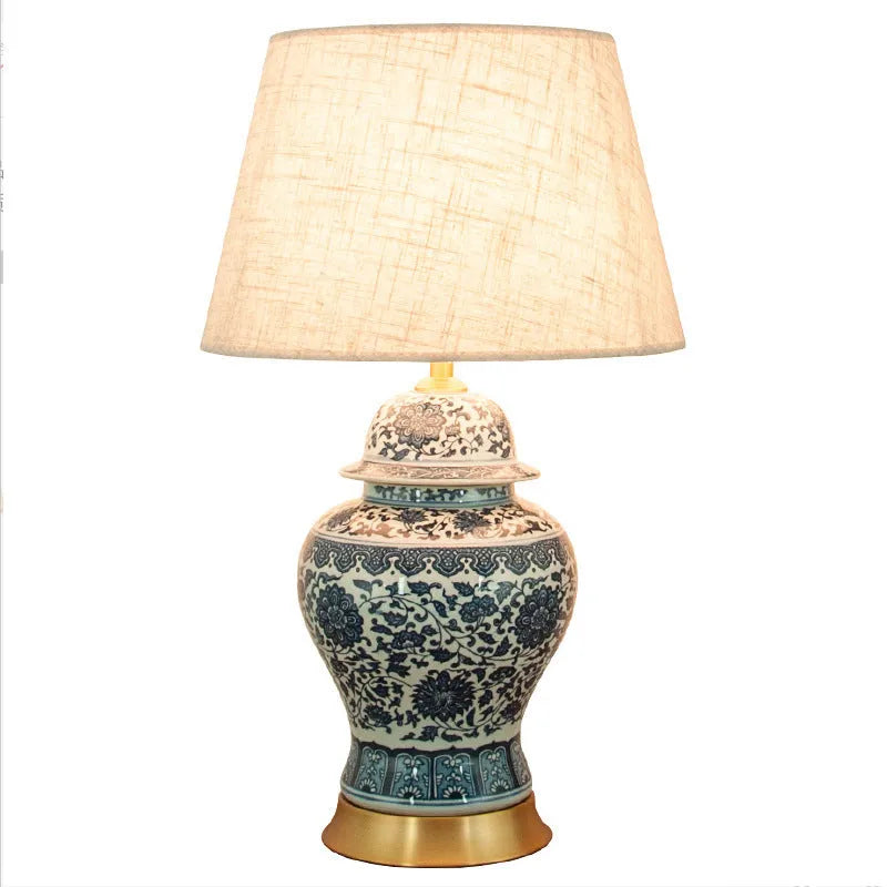 Chinese blue and white porcelain table lamp with cloth shade on wooden surface