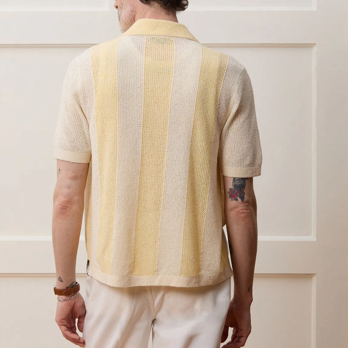 Yellow short-sleeved polo shirt with asymmetric design and hollow-out pattern details