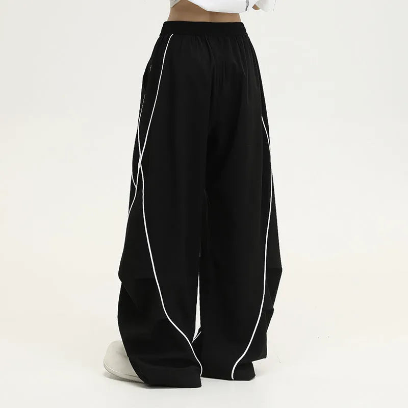 Black pleated wide-leg hip hop trousers with a striped pattern on a mid waist.