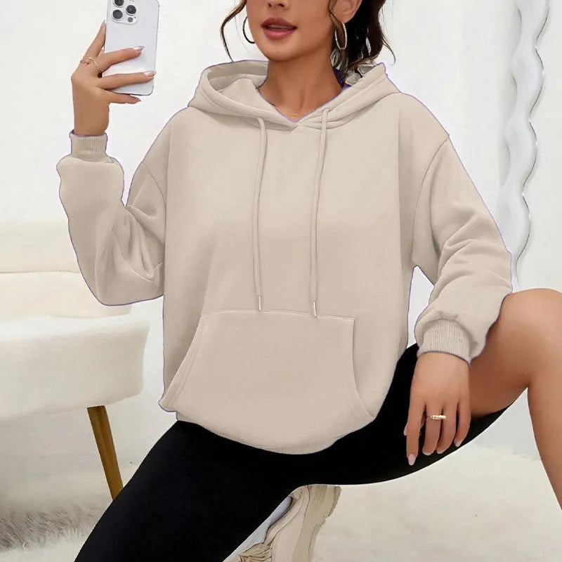 Women's loose grey drawstring hooded sweatshirt with side pockets, on a hanger.