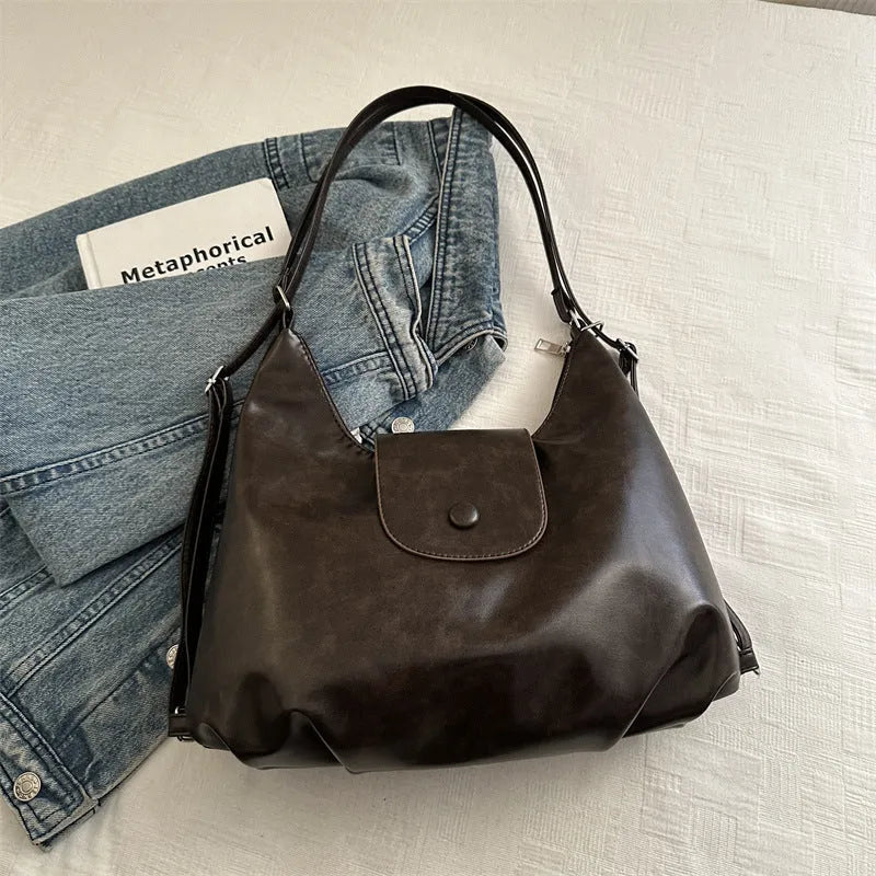 Textured PU leather commuter shoulder backpack in horizontal square shape with single strap and mobile phone compartment