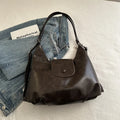 Textured PU leather commuter shoulder backpack in horizontal square shape with single strap and mobile phone compartment