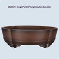 A large, simple purple clay bonsai pot on a table, suitable for indoor plants.