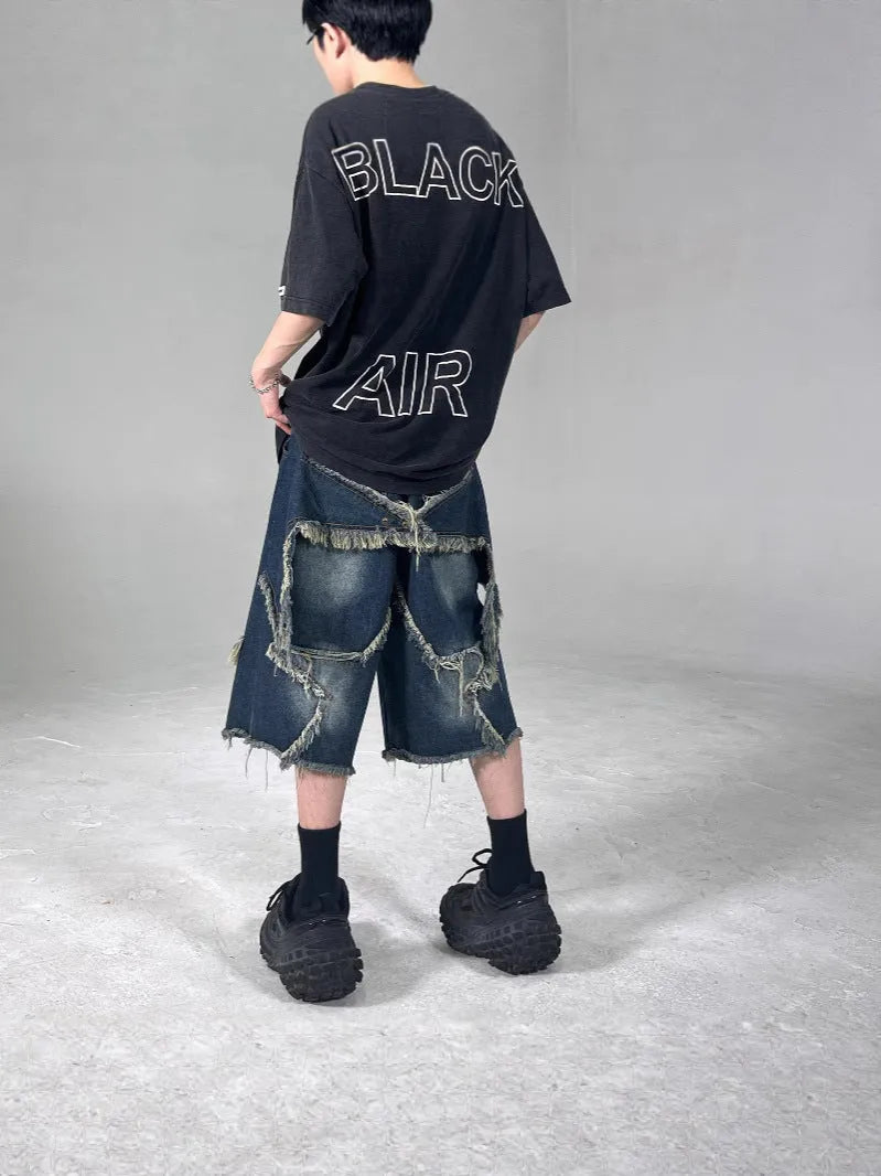 Blue denim shorts with frayed five-pointed star design in loose retro style