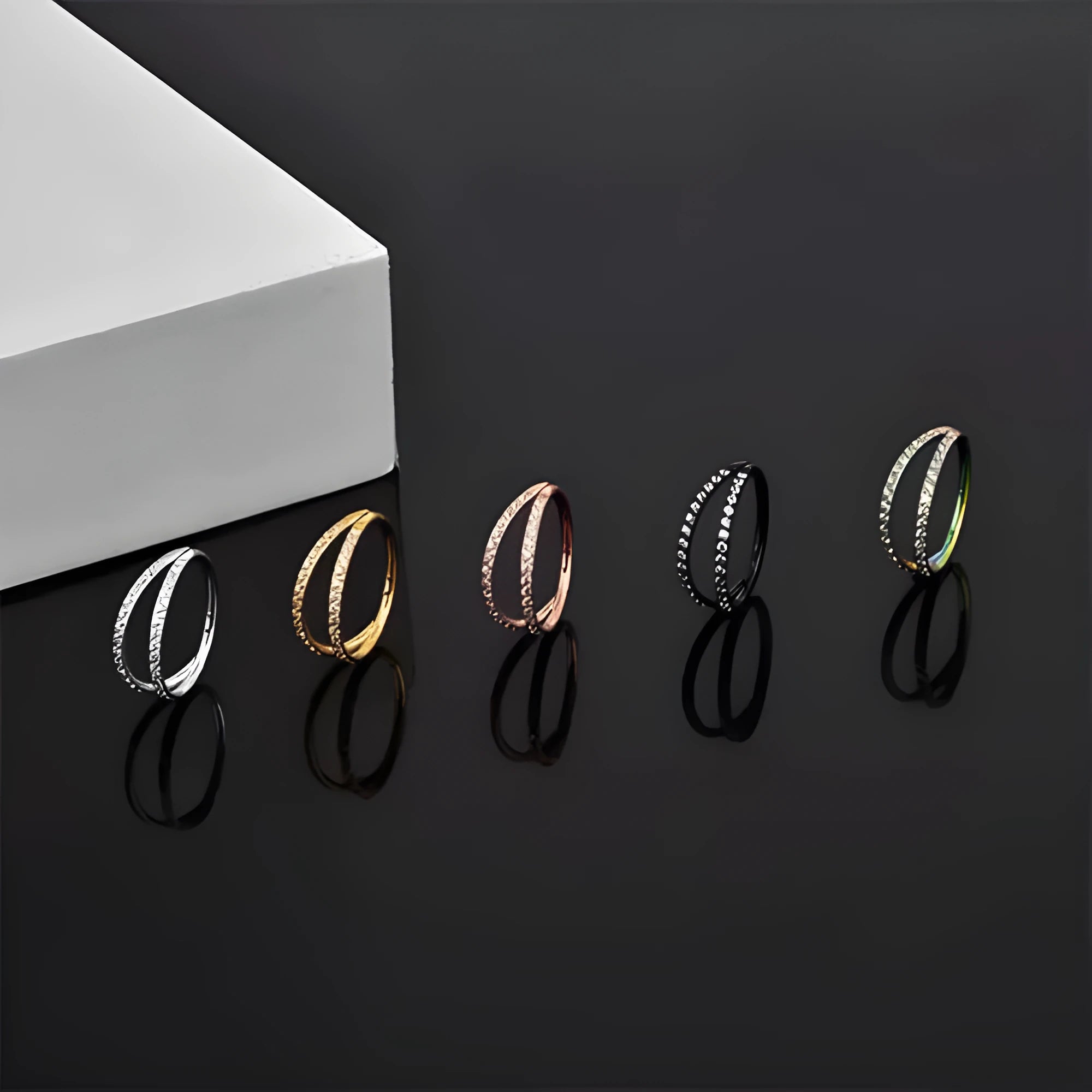 Close-up of a G23 titanium alloy nose or ear ring with a small zircon gemstone, shown in a gold tone finish.