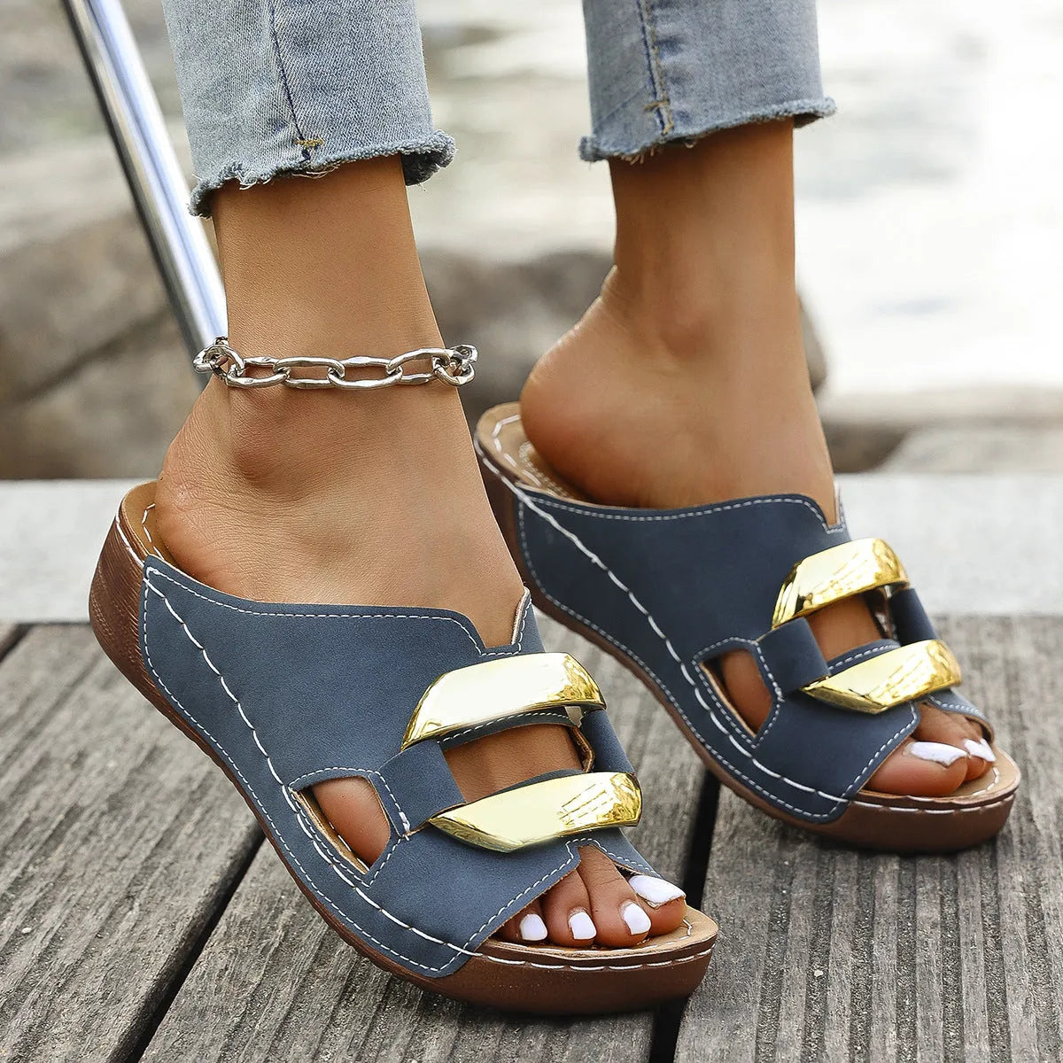 Roman-style platform flip-flop sandals in white, showing flat heel and metal detail.