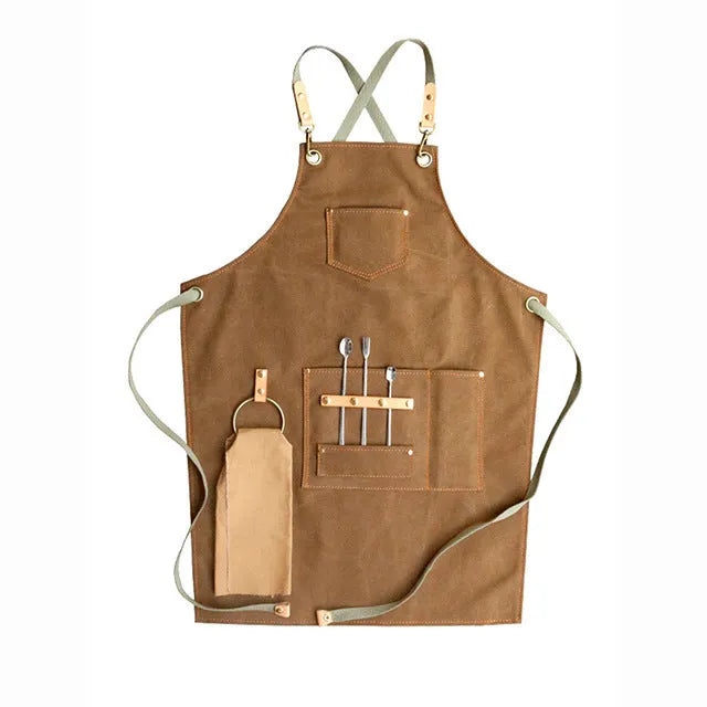 Canvas apron with cross-back straps in camel colour, shown laid flat