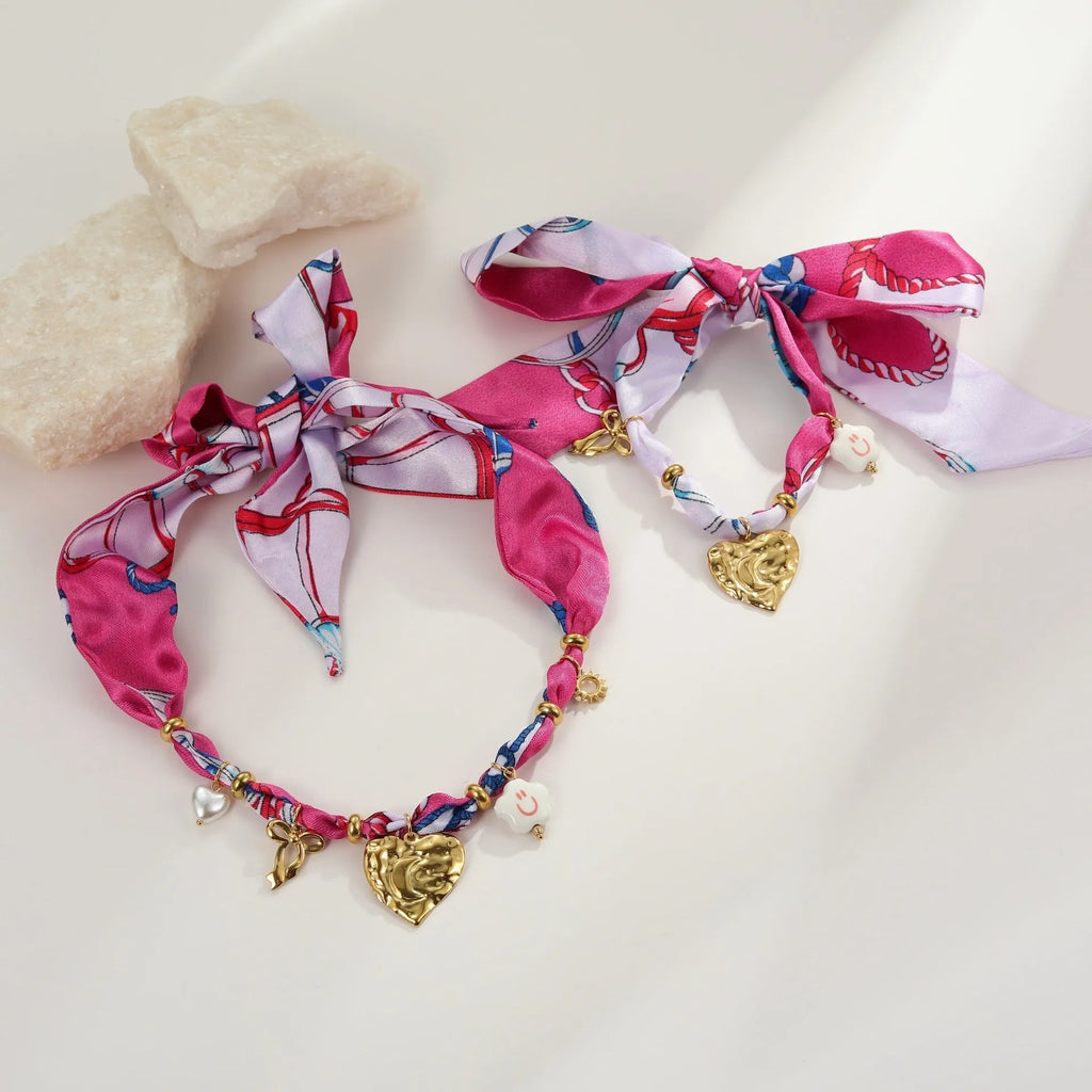 Gold geometric love pendant necklace and matching bracelet set on a white background