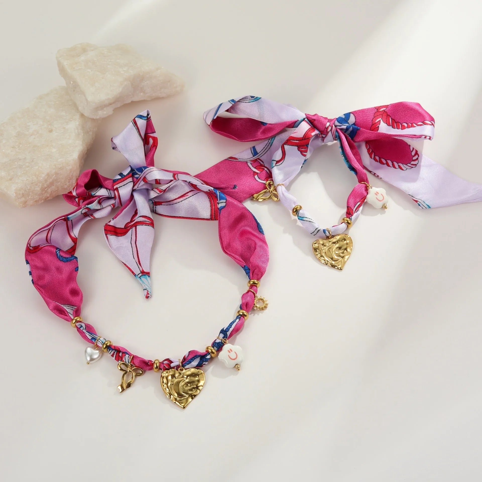 Gold geometric love pendant necklace and matching bracelet set on a white background