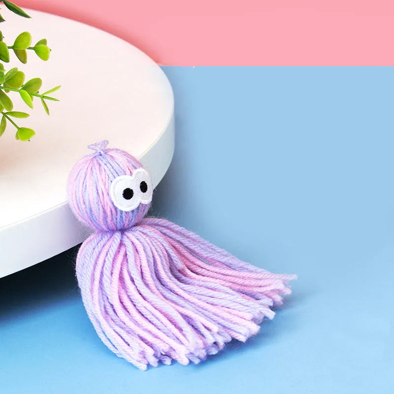 Wool cat toy ball with hanging string in blue grey, pink and blue, or pink purple colours for biting and scratching