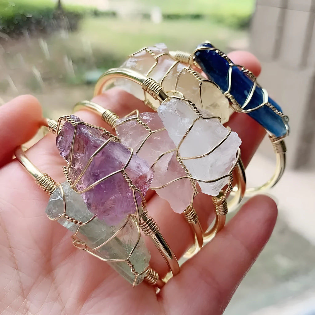Explosive design natural crystal rough stone bracelet with gold winding on a wrist.