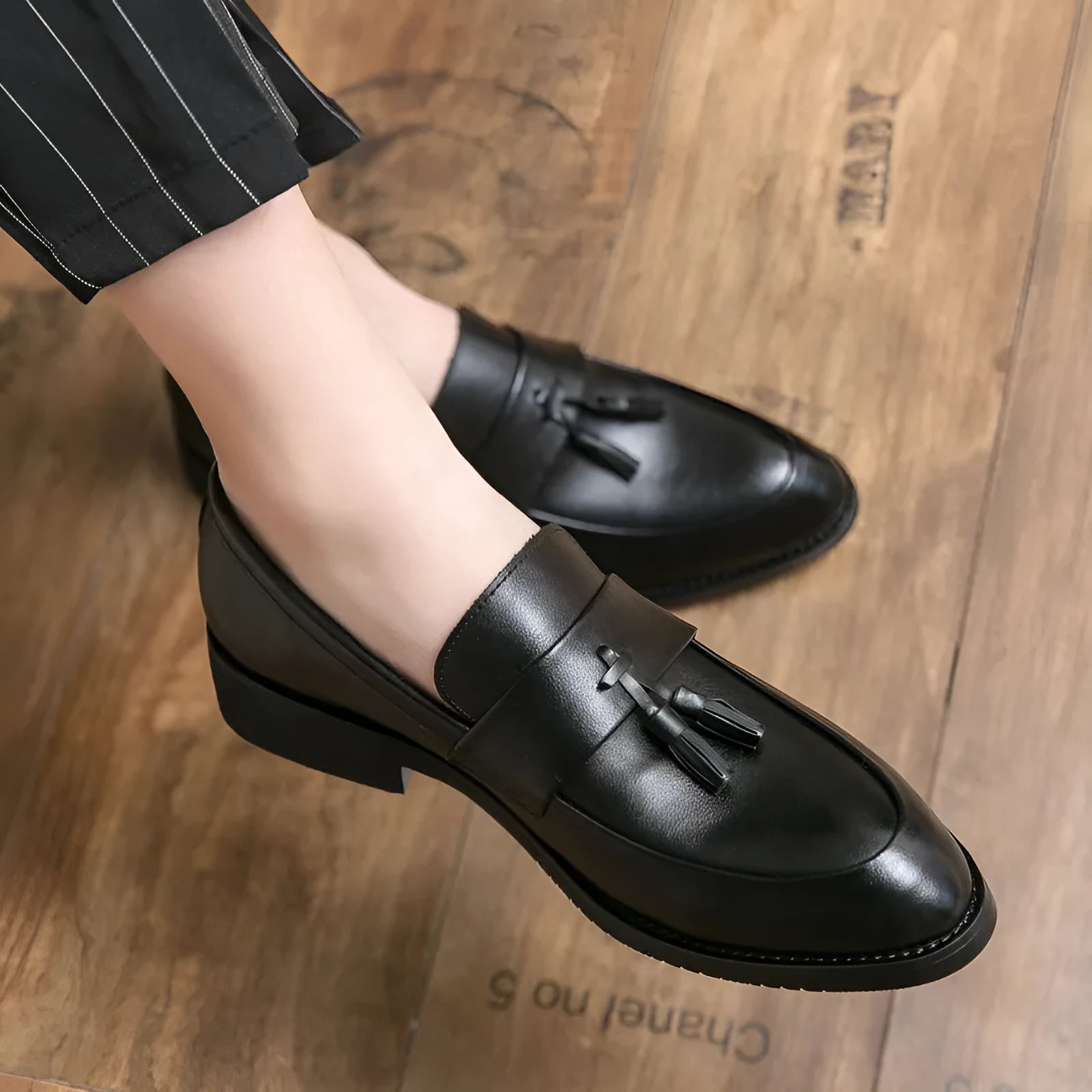 Men's black slip-on loafers with tassel detail and rubber sole for business casual wear