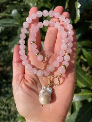 Women's handmade stainless steel pink crystal bracelet and necklace set, modern minimalist 10mm jewellery on a flat surface