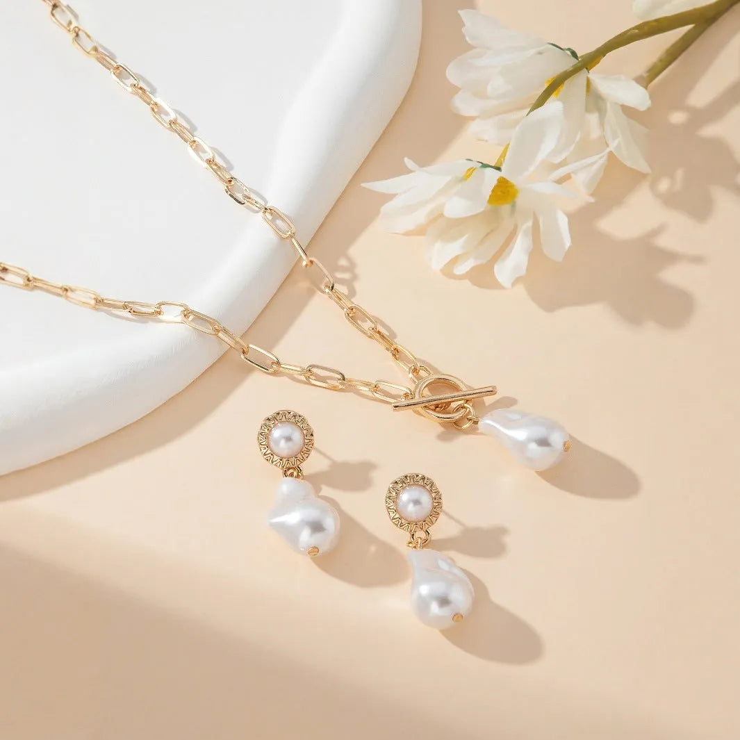 Gold-colour baroque pearl necklace and stud earrings jewellery set on display