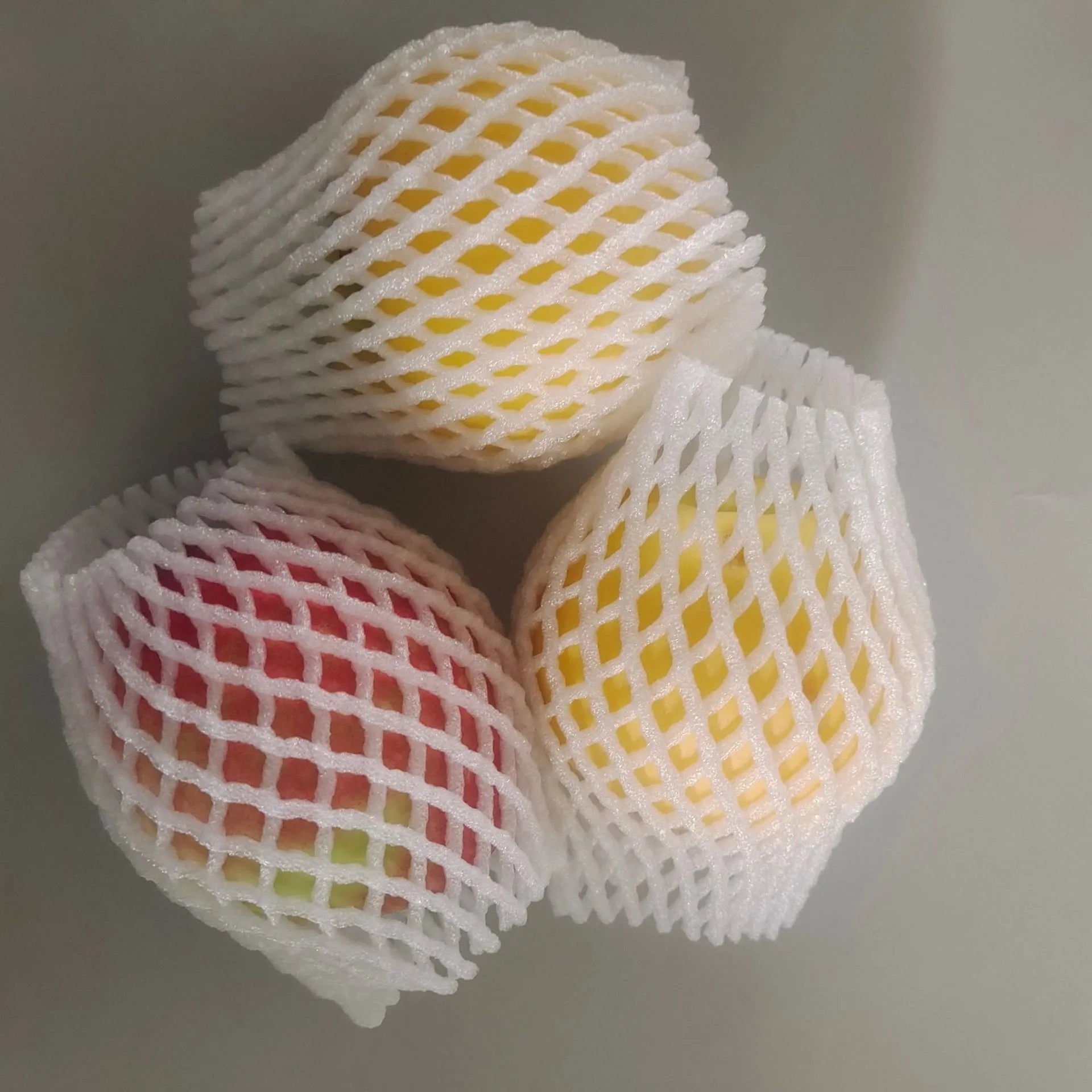 White foam net cover for fruit protection shown in various sizes on a table.