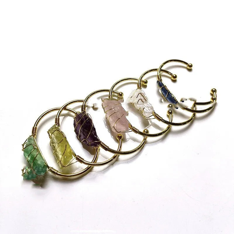 Explosive design natural crystal rough stone bracelet with gold winding on a wrist.