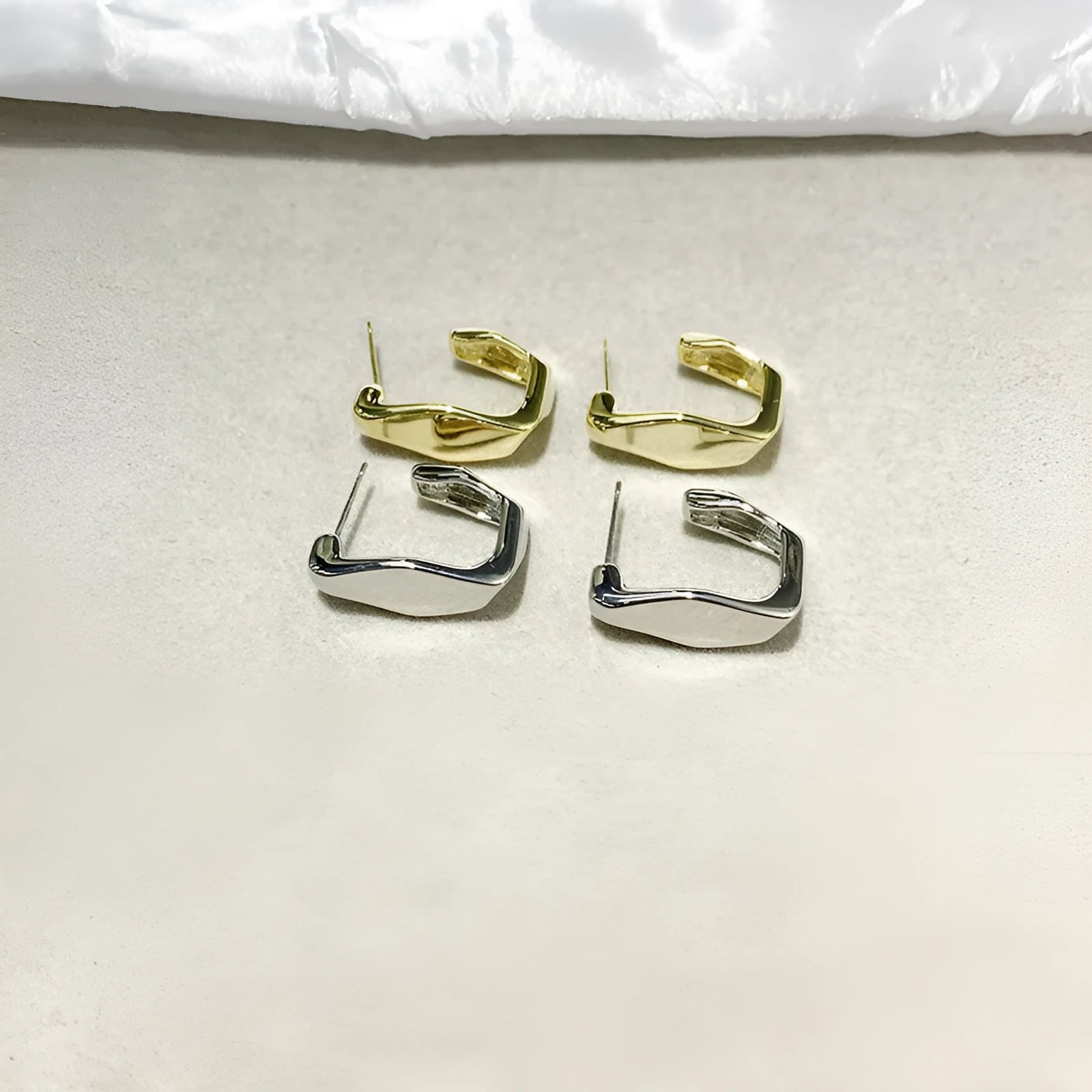 Irregular C-shaped metal stud earrings in Gold finish, minimalist design for everyday wear.