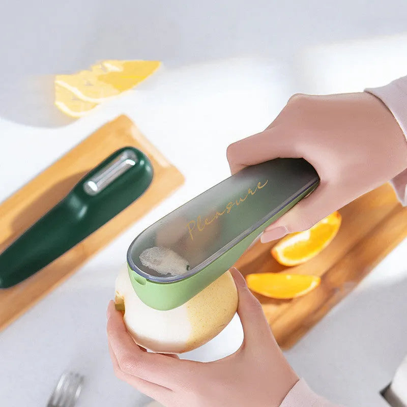 Dark green kitchen peeler with stainless steel blade stored in its tube, next to a potato.