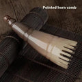 Black and white buffalo horn comb with wide teeth and a pointed end for hair massage and detangling.
