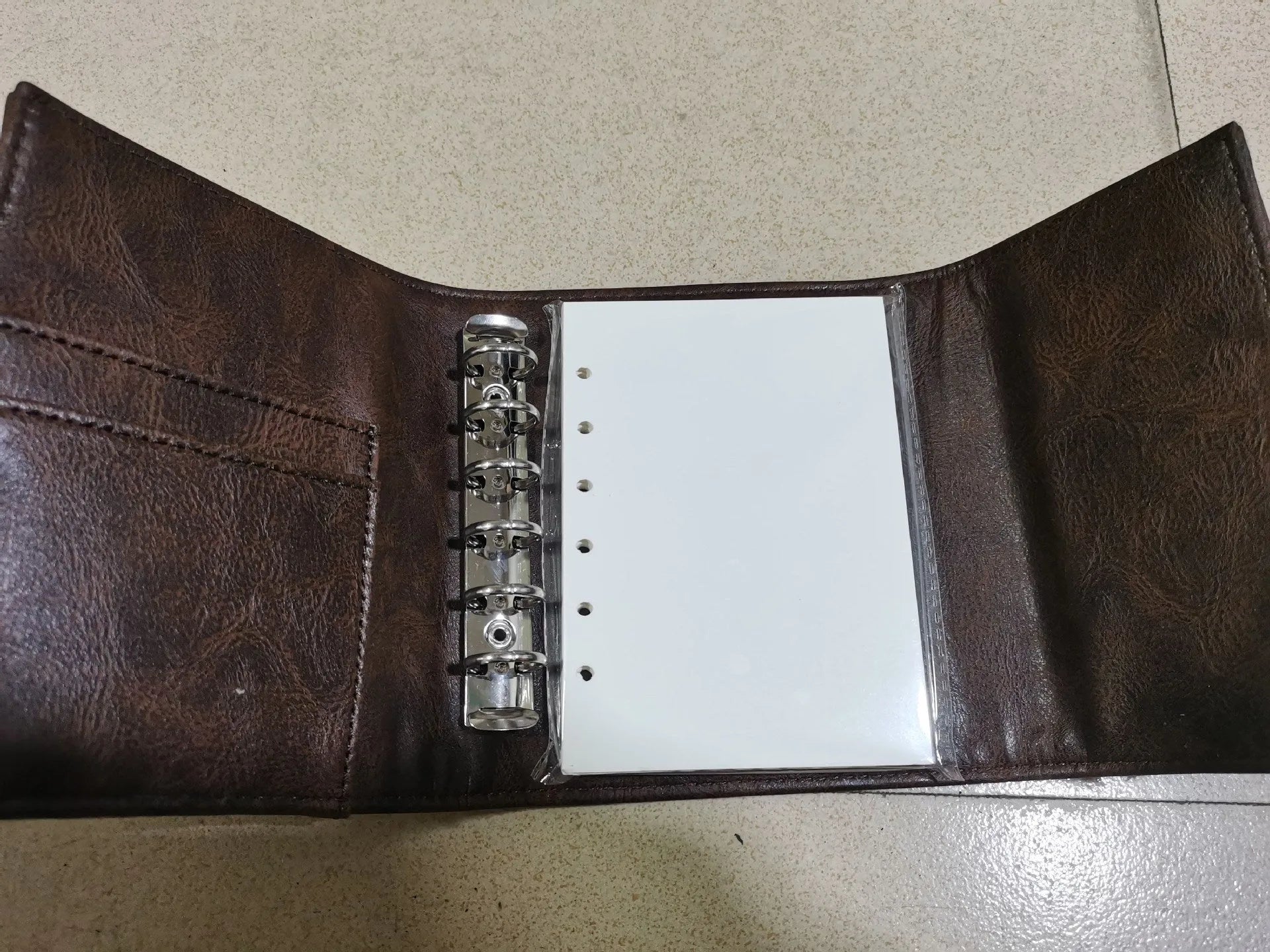 Brown retro leather-style A7 notebook with buckle closure and loose-leaf binding