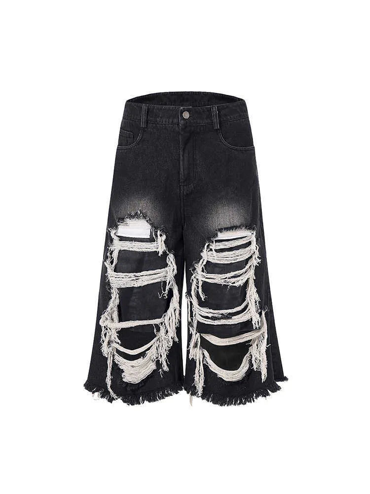 Black cropped wide leg jeans with mid-high waist and ripped patch detail on a loose fit.