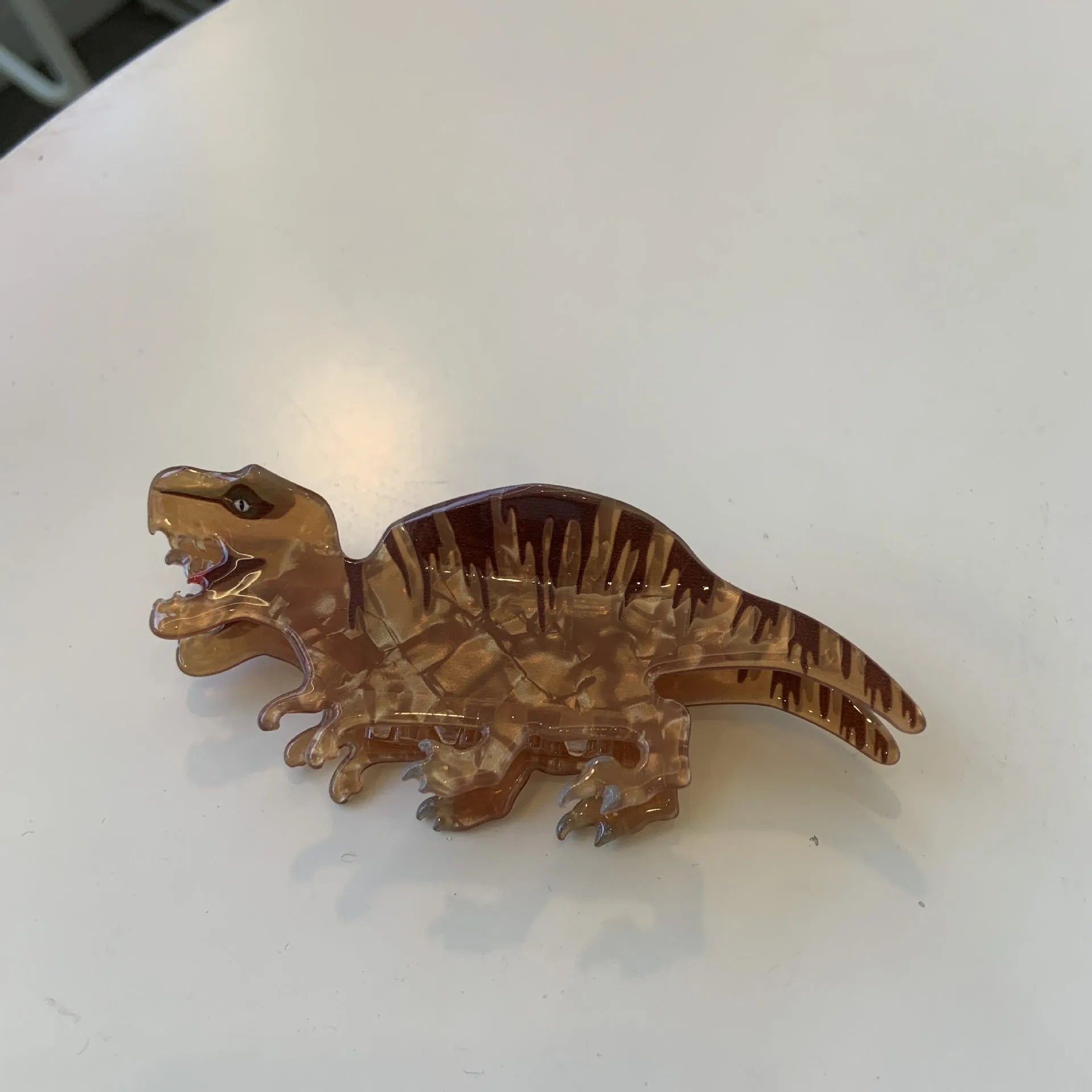 Dinosaur-themed acrylic jaw hair clip showing six colour variations with grip mechanism