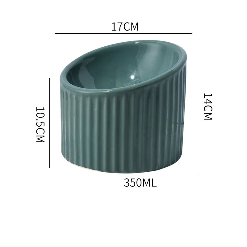 A dark green ceramic elevated cat bowl with a tilted, round design on a wooden surface.
