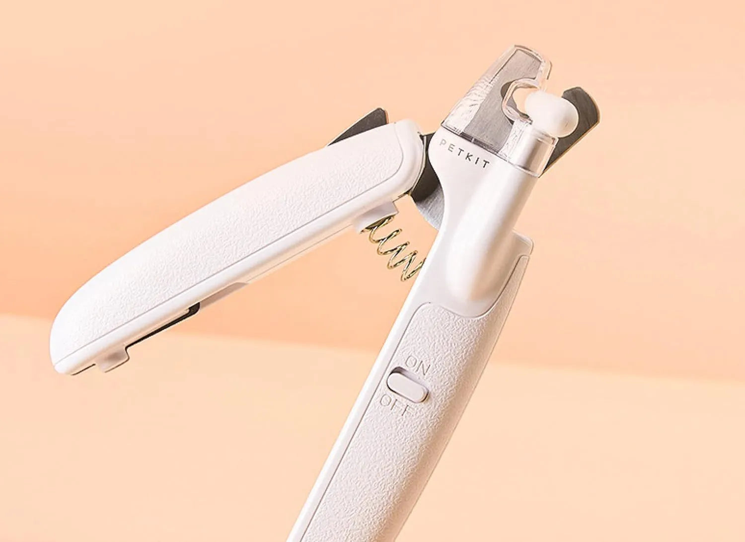 White LED pet nail clippers with transparent guard, triangular blade, and anti-slip handle next to a filing tool.
