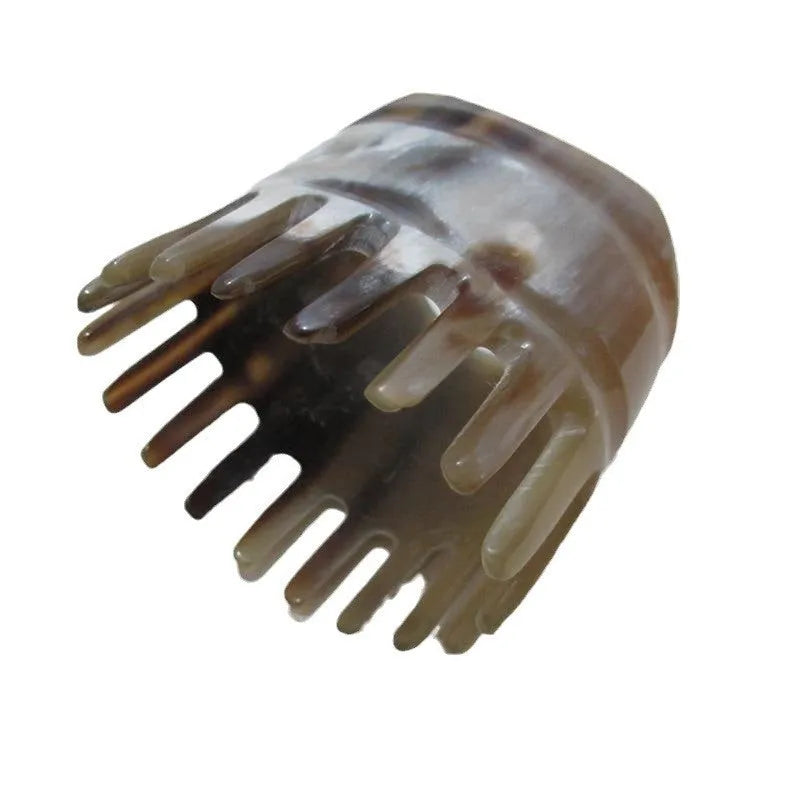 Black and white buffalo horn comb with wide teeth and a pointed end for hair massage and detangling.