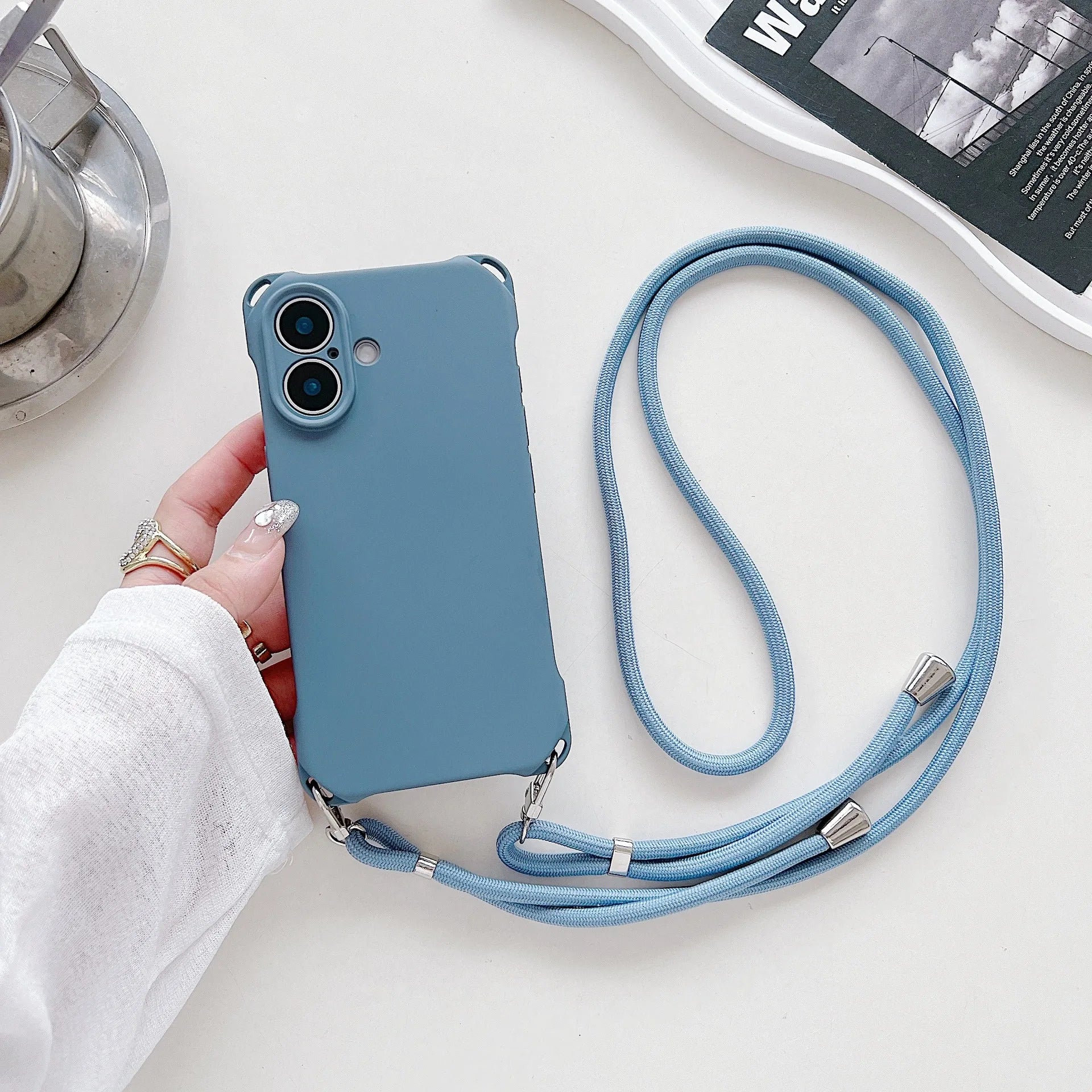 Four-corner cross lanyard liquid silicone phone case for Apple iPhone 16 in antique white with matching lanyard