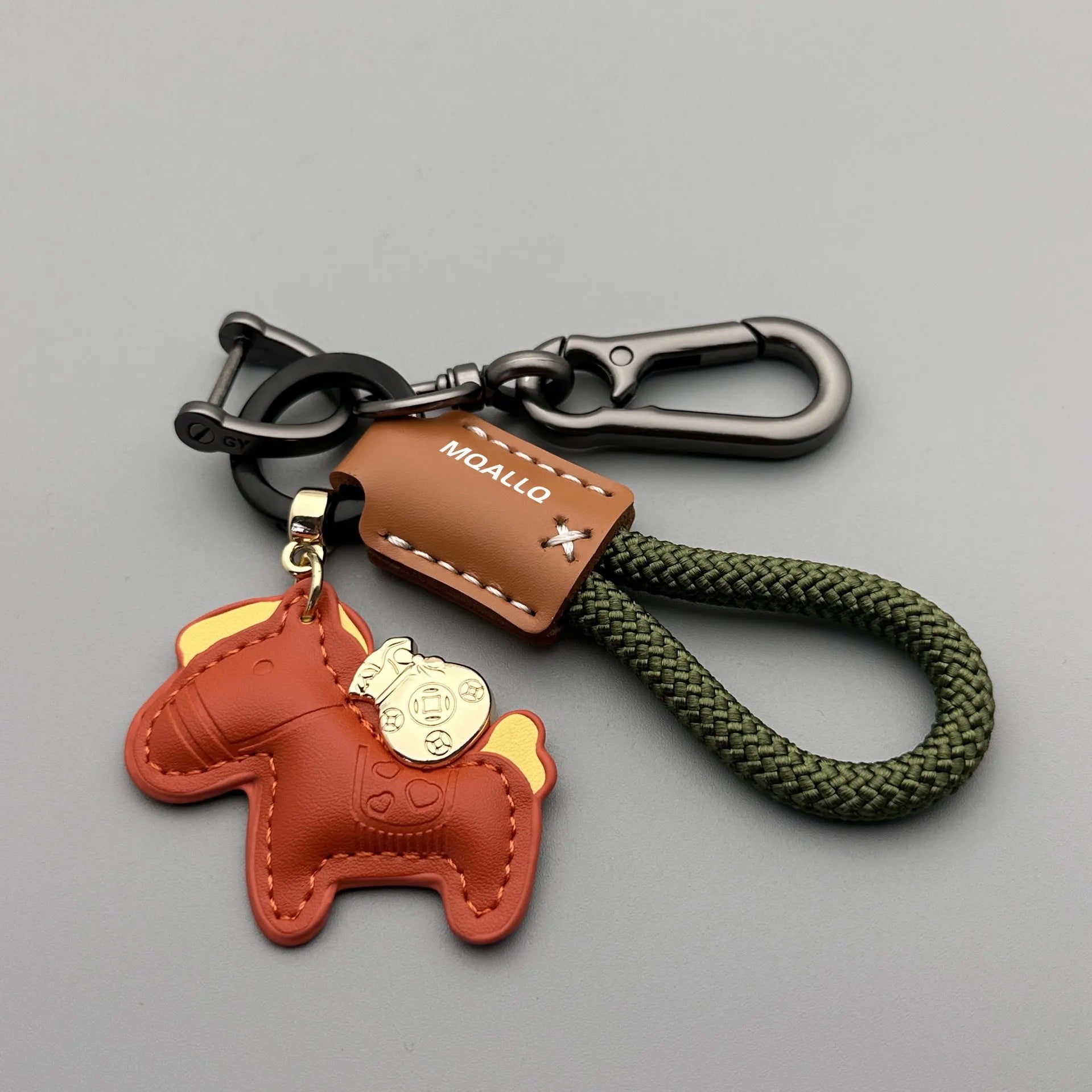 Handmade brown cowhide key pendant with a green flannel rope and a gold-toned horse-shaped buckle.