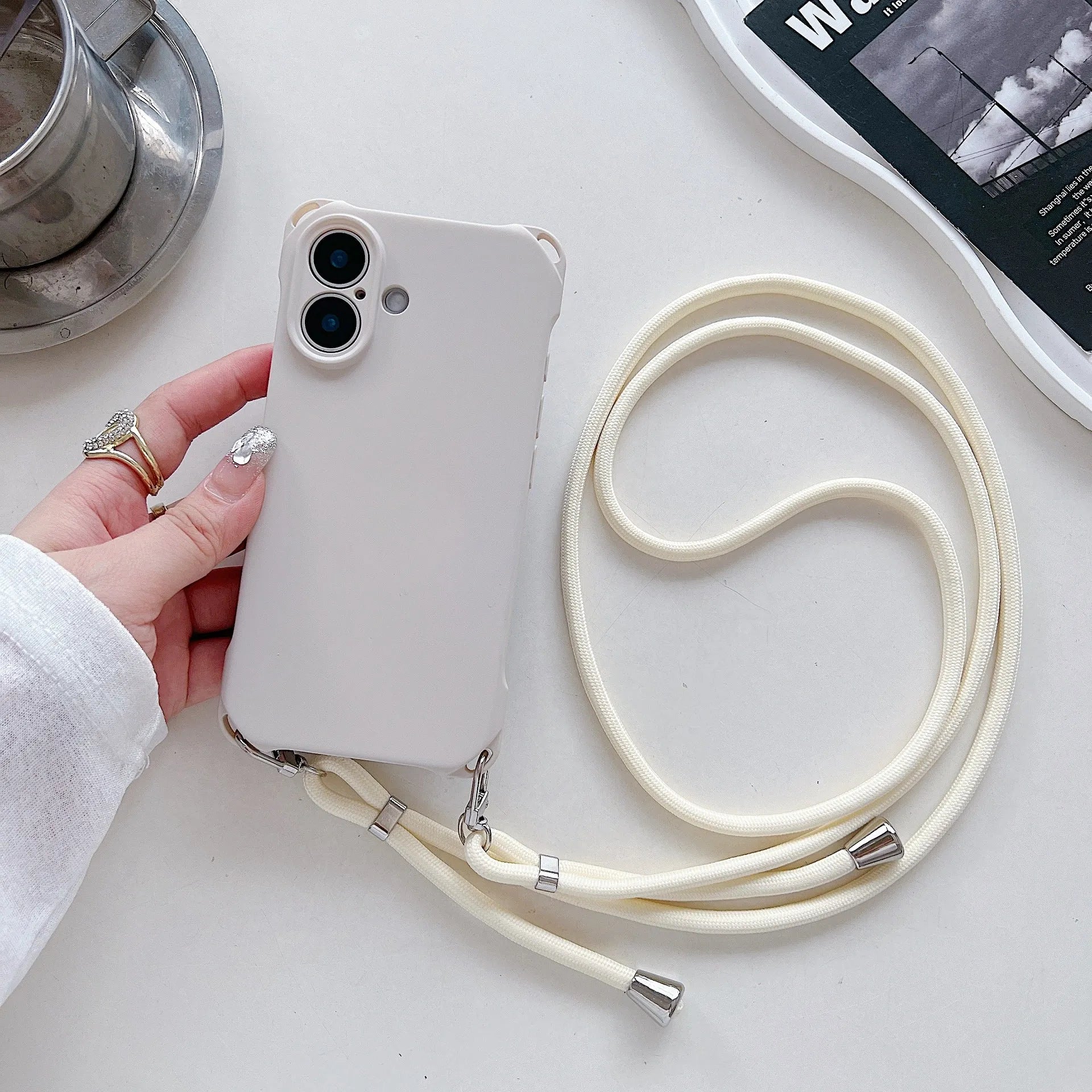 Four-corner cross lanyard liquid silicone phone case for Apple iPhone 16 in antique white with matching lanyard