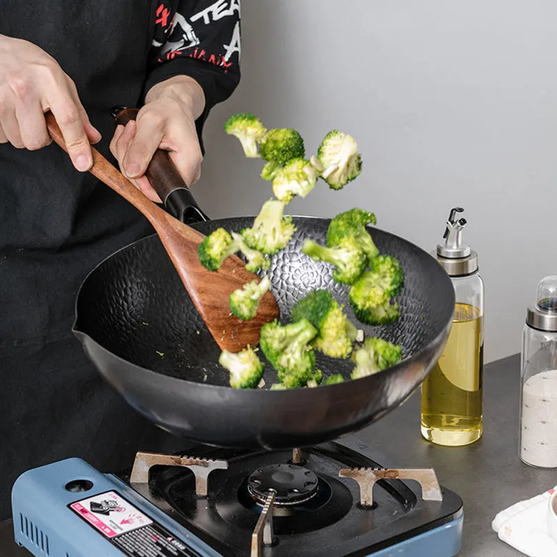 Traditional black iron wok with long wooden handle measuring 32cm diameter