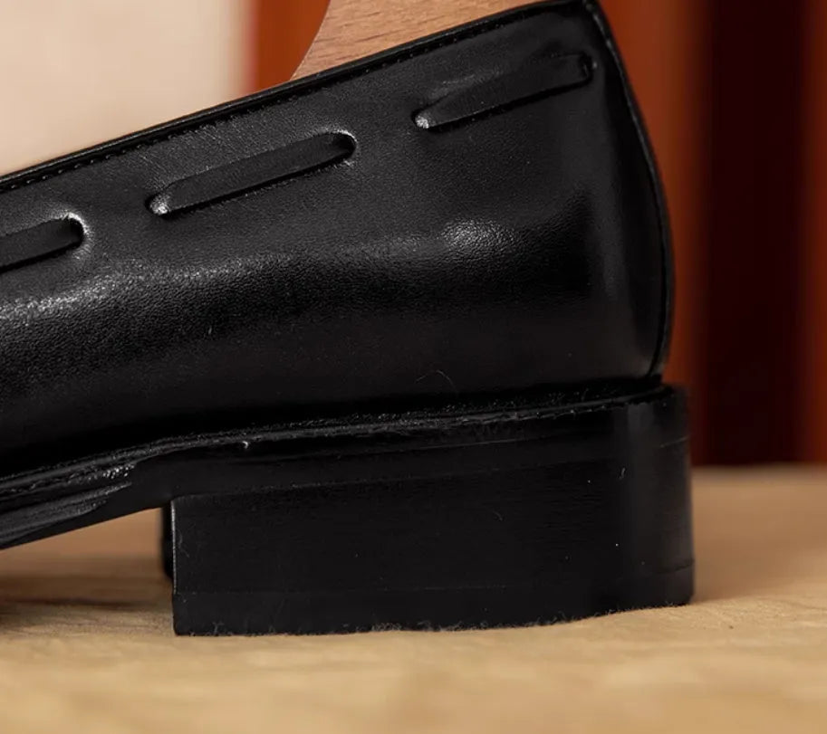 Men's black genuine leather slip-on loafers showing polished finish and rubber sole