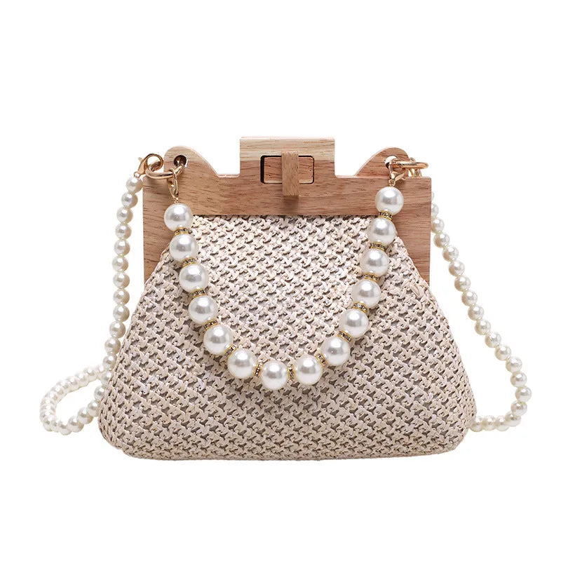 Women's straw woven shoulder bag with pearl chain detail showing interior organisation compartments