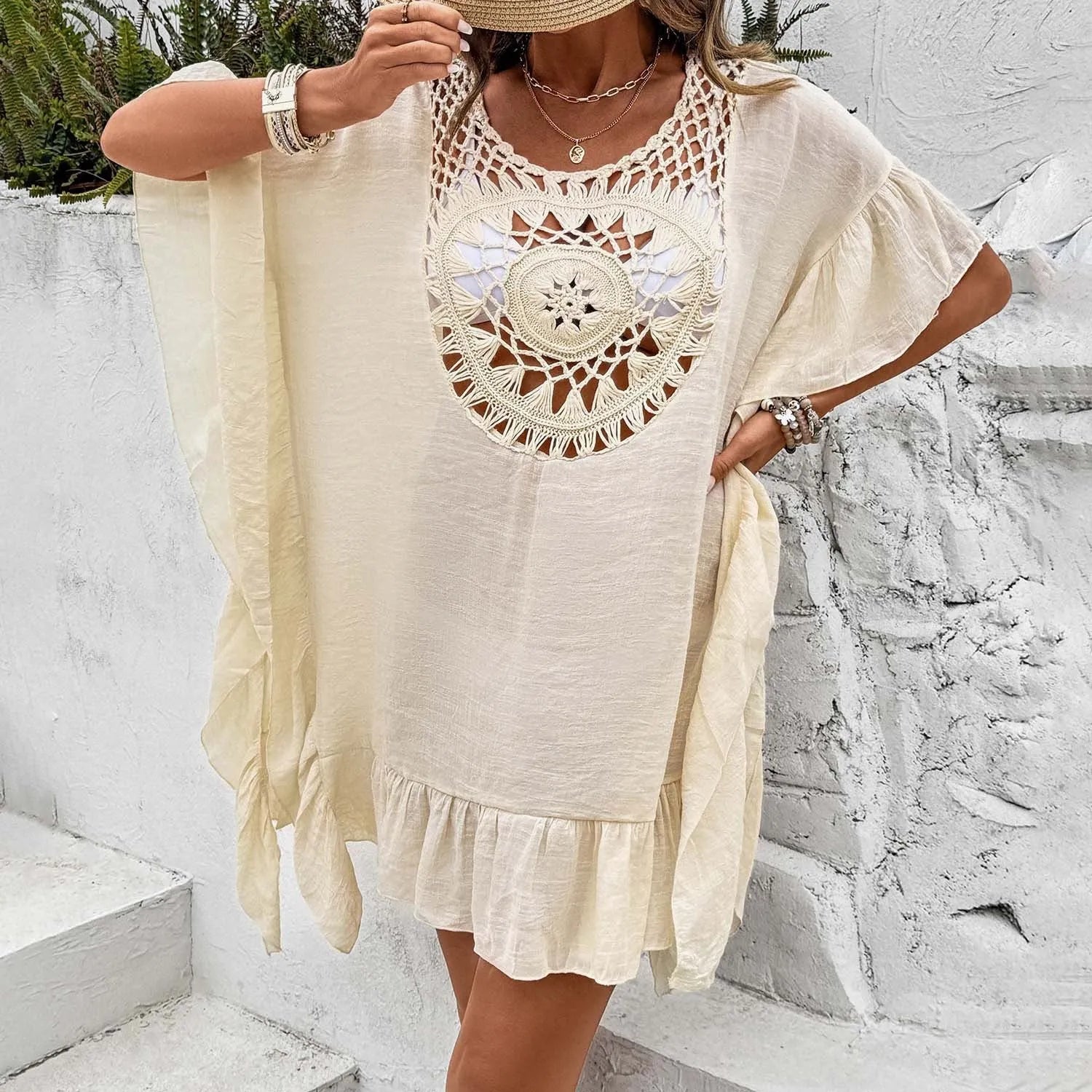 Crochet stitch patchwork beach cover-up dress in apricot colour, showing tassel details and textured fabric.